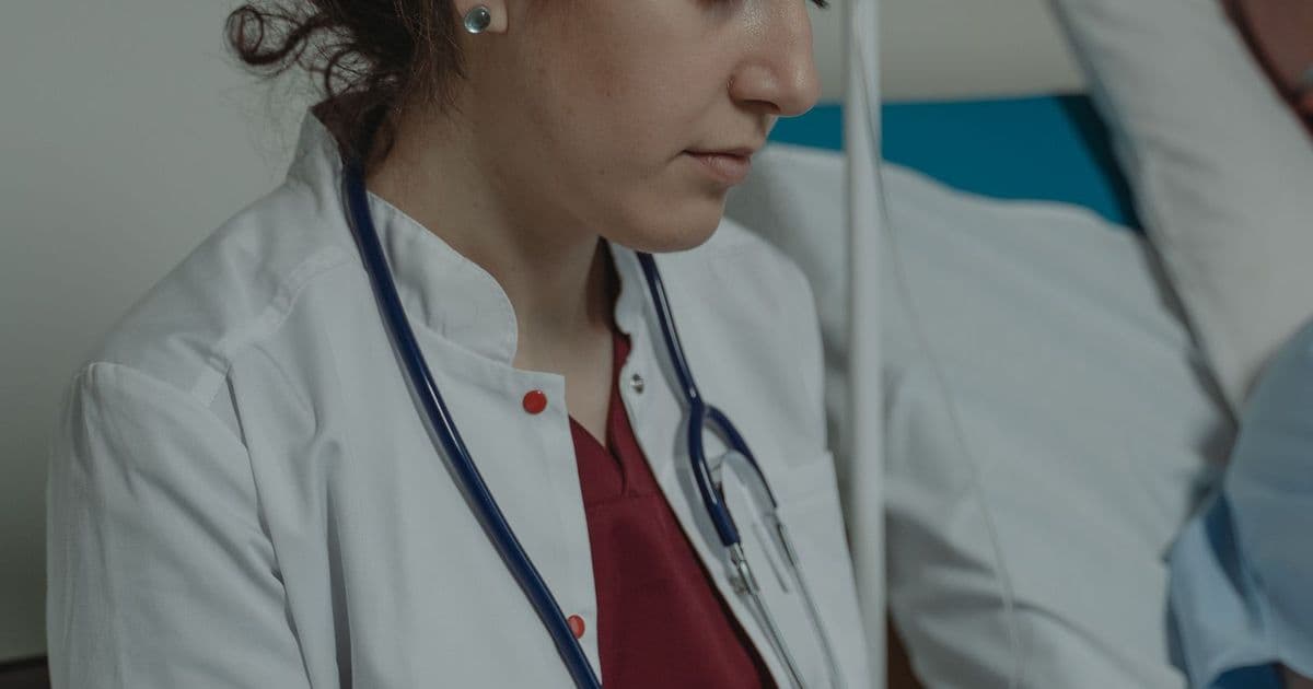 Une médecin prend des notes sur un dossier