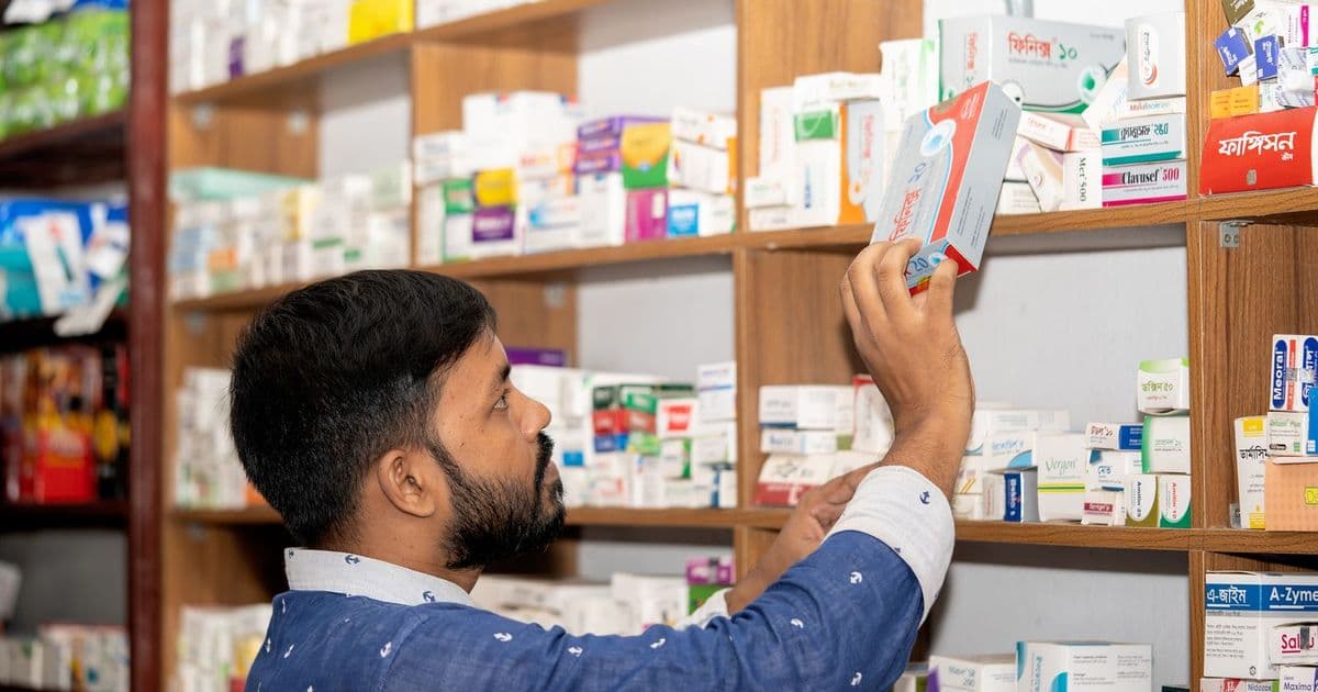 Un pharmacien range des médicaments sur les étagères