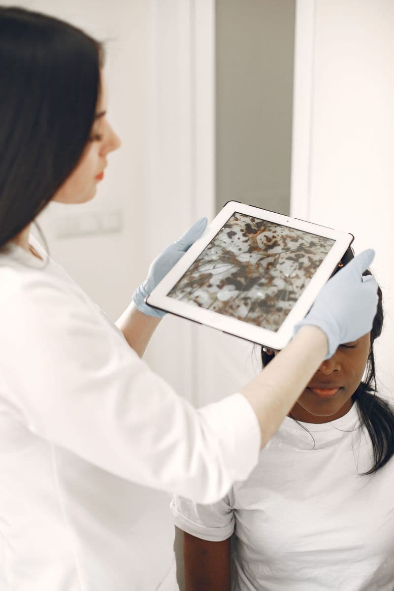 Une professionnelle de santé examine la peau d’une patiente avec un outil numérique