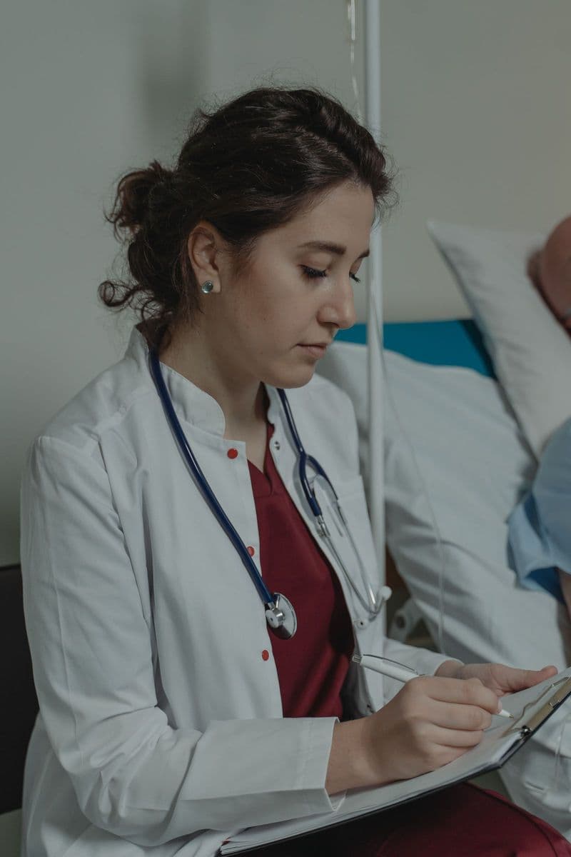 Une médecin prend des notes sur un dossier